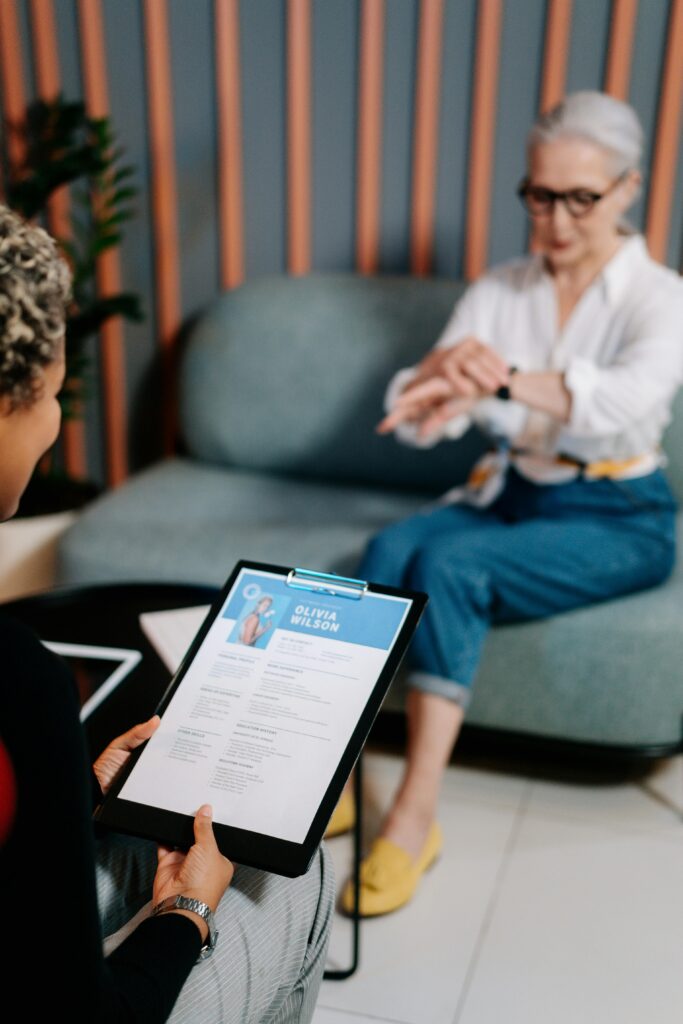 pexels photo 5989924 5989924 A senior woman being interviewed indoors with her resume displayed.